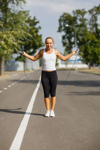 İp atlama ile güzel kız. Park arka plan üzerinde atlama spor kadın. Aktif yaşam tarzı kavramı.