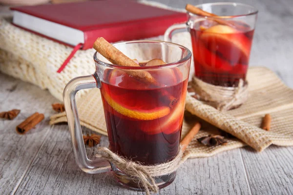 Tarçın ve kırmızı kitap üzerinde hafif bir arka plan üzerinde bir eşarp ile limonlu çay. Sıcak içecekler. Rahat ev atmosfer.