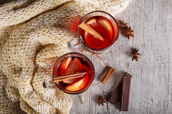 Sıcak çay ve tatlılar bir eşarp ahşap arka plan üzerinde yanındaki bir kış gününde. Ev atmosfer. Çay ve çikolata.