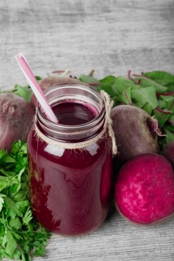 Ahşap arka plan üzerinde bir cam kavanoza pancar kokteyl. Kesme beetroots ve yeşillik. Sağlıklı sebze güler yüzlü. Kopya alanı.