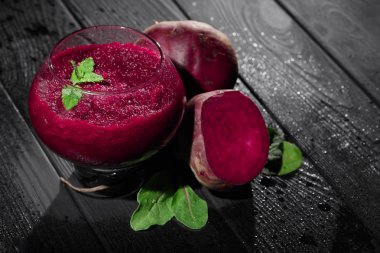 Pancar içecek bir bardak. Vejetaryen smoothies. Beetroots ve yeşillik siyah ahşap zemin. Detoks için malzemeler.