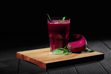 Pancar ürünler siyah bir arka plan üzerinde. Olgun kırmızı pancar ve yeşillik bir kesme masasında. Vejetaryen Cafe konsept. Kopya alanı.