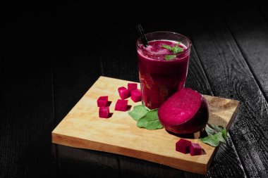 Sebzeli içki güzel bileşimi. Pancar pancar siyah bir zemin üzerine güler yüzlü ve kesim. Pancar ürünleri. Kopya alanı.