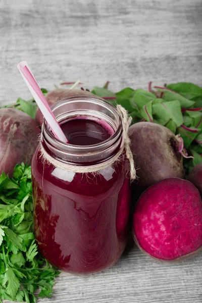 Ahşap arka plan üzerinde bir cam kavanoza pancar kokteyl. Kesme beetroots ve yeşillik. Sağlıklı sebze güler yüzlü. Kopya alanı.