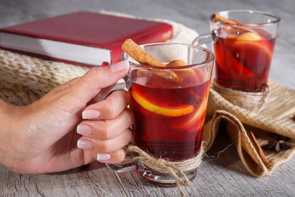 Baharatlı kırmızı çay bir tablo arka planda tutan yakın çekim kadın. Sıcak çay ve yün, İpek eşarp. Tıbbi limon çayı.