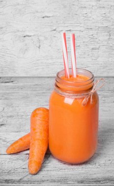 Havuç düzgün pipetleri ve havuç hafif ahşap arka plan vitamin dolu ile güler yüzlü. Havuç, taze suyu yakın çekim. Sebze kavramı. Sağlıklı portakal suyu.