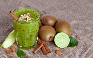 Açık kahverengi renkli olarak kivi, Sulu kireç ve bir dilim elma yığını organik bir bileşimi bir görüntü yukarıdan. Egzotik meyve dolu kumaş üzerinde Besleyici vitaminler dan sağlıklı kokteyl.