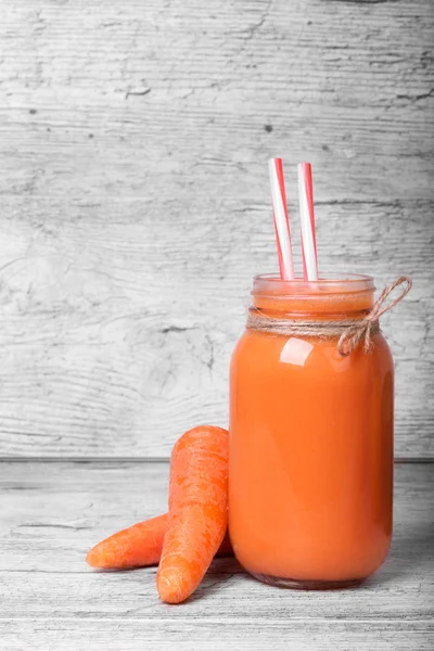 Havuç düzgün pipetleri ve havuç hafif ahşap arka plan vitamin dolu ile güler yüzlü. Havuç, taze suyu yakın çekim. Sebze kavramı. Sağlıklı portakal suyu.