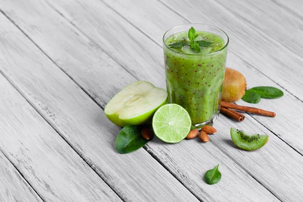 gri bir ahşap zemin üzerine cam yüzlü kivi, elma ve limon nane ile Üstten Görünüm.