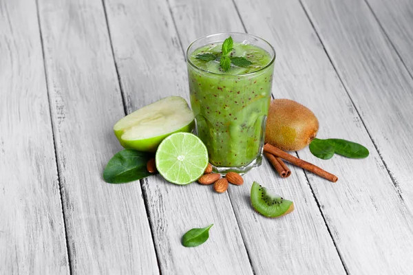 gri bir ahşap zemin üzerine cam yüzlü kivi, elma ve limon nane ile Üstten Görünüm.