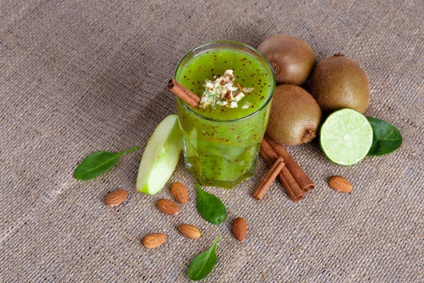 Açık kahverengi renkli olarak kivi, Sulu kireç ve bir dilim elma yığını organik bir bileşimi bir görüntü yukarıdan. Egzotik meyve dolu kumaş üzerinde Besleyici vitaminler dan sağlıklı kokteyl.