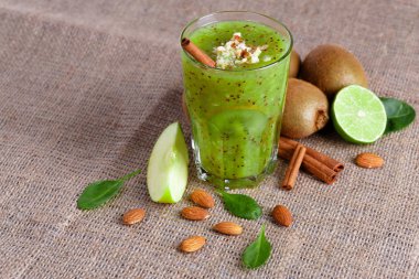 Bir yığın bir doğal kivi ve kireç görünümünü yukarıda hafif kahverengi kumaş arka plan üzerinde ikiye böldüm. Tropikal meyve ve rendelenmiş badem bir tabloda bir sağlıklı güler yüzlü. Kopya alanı.