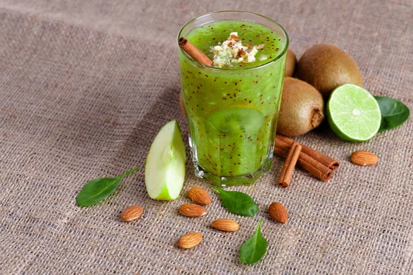 Bir yığın bir doğal kivi ve kireç görünümünü yukarıda hafif kahverengi kumaş arka plan üzerinde ikiye böldüm. Tropikal meyve ve rendelenmiş badem bir tabloda bir sağlıklı güler yüzlü. Kopya alanı.