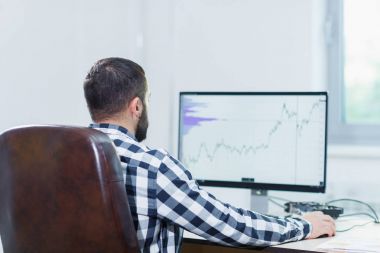 Bir dizüstü bilgisayarda projeleri yönetmek için yazılım kullanan bir adam