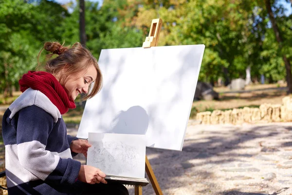 Kadın sanatçı sonbahar parkta bir resim boyama. — Stok fotoğraf