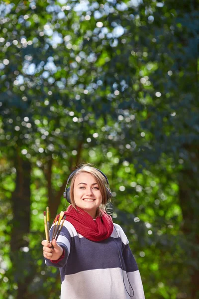 Schöne Künstlerin zeichnet gut gelauntes Bild im Freien. — Stockfoto