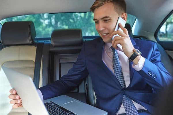 Pewni biznesmen rozmowy na telefon komórkowy siedząc na tylnym siedzeniu samochodu — Zdjęcie stockowe