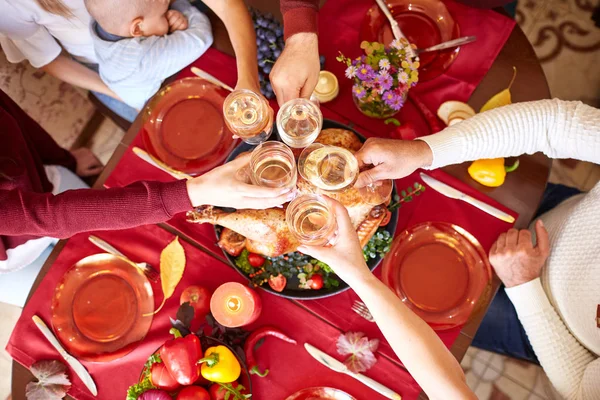 Close-up family clinking glasses on Thanksgiving on a table background. Cheers with champagne. Celebration concept. — Stock Photo, Image