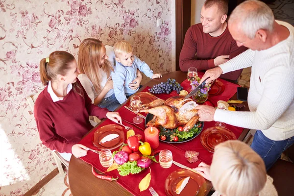 Happy family at the dinner table celebrating Thanksgiving on a blurred background. Traditional Thanksgiving concept. — Stock Photo, Image