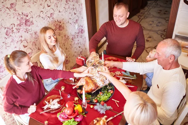 Family cheering and drinking on Thanksgiving on a blurred background. Family holiday gathering concept. — Stock Photo, Image