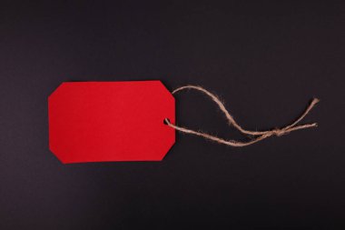 Siyah bir zemin üzerine parlak kırmızı etiket close-up. Siyah Cuma.