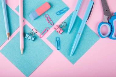 Bir close-up mavi ve pembe ofis parlak pembe bir arka plan üzerinde. Yukarıdan görüntüleyin. Mavi ve pembe ofis. Çok fazla okul nesne.
