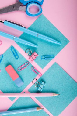 Bir close-up mavi ve pembe ofis parlak pembe bir arka plan üzerinde. Yukarıdan görüntüleyin. Mavi ve pembe ofis. Çok fazla okul nesne.
