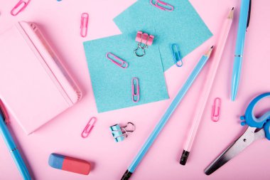 Bir close-up mavi ve pembe ofis parlak pembe bir arka plan üzerinde. Yukarıdan görüntüleyin. Mavi ve pembe ofis. Çok fazla okul nesne.