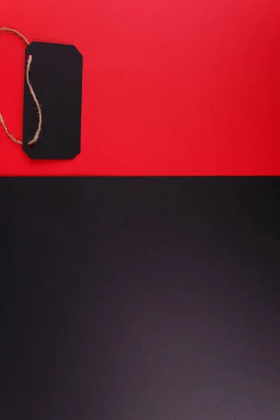 Close-up of two black and red backgrounds, on a bright red background arranged black tags.