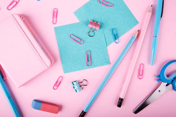 Bir close-up mavi ve pembe ofis parlak pembe bir arka plan üzerinde. Yukarıdan görüntüleyin. Mavi ve pembe ofis. Çok fazla okul nesne.