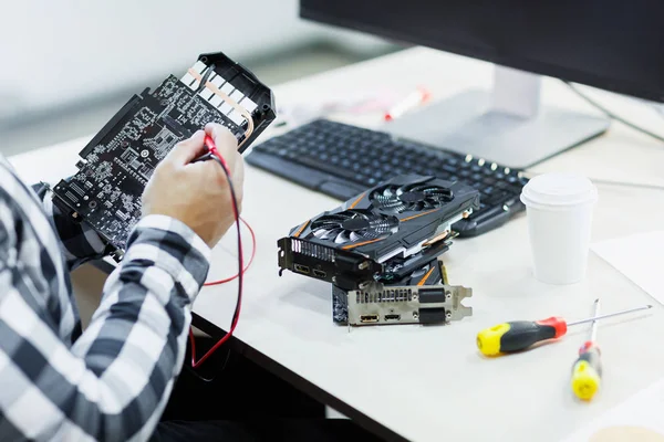 Close-up of a man who repairs a video card. Cryptocurrency. Business and finance concept.