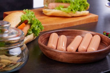 Turşulu sosisli, domates ve marullu ahşap arka planda. Üst görünüm