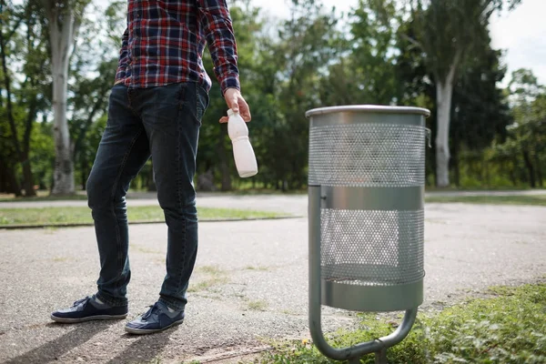 Bir kağıt bardak yeşil park dışında sol alt kapak üzerinde odaklanın. Çim güneşli Park, plastik şişe bulanıklık yeşil doğa arka plan ile yeşil Park'ta çöp yığını.