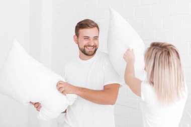 Genç bir çift yastık yatak odasında atıyor.