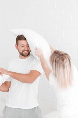 Genç bir çift yastık yatak odasında atıyor.