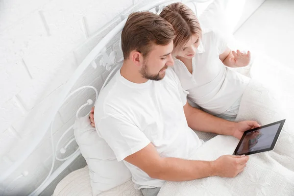 Красива молода пара використовує планшетний ПК в ліжку . — стокове фото