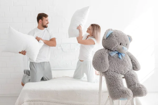 Una joven pareja está golpeando almohadas en el dormitorio . — Foto de Stock
