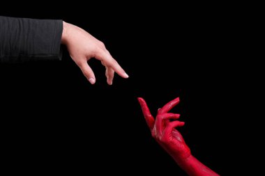 İnsan eli kırmızıyla boyalı siyah bir arka plan üzerinde poz olan.