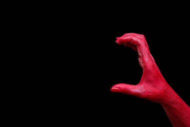 İnsan eli kırmızıyla boyalı siyah bir arka plan üzerinde poz olan.