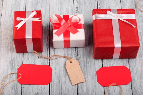 Hermosas cajas de regalo con un lazo rojo y blanco sobre un fondo de madera . — Foto de Stock