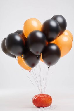 Turuncu ve siyah balon ve hafif bir arka plan üzerinde bir Cadılar Bayramı partisi için bir kabak. Halloween süslemeleri.