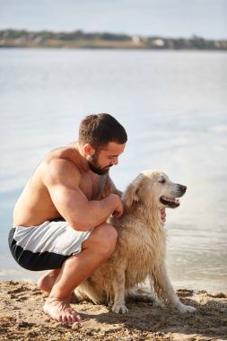 Mutlu köpek labrador zevk sahibi ile sahilde oynarken.