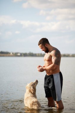 Mutlu labrador zevk sahibi ile sahilde oynarken.