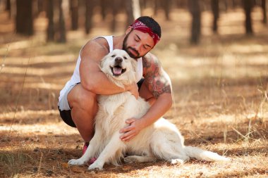 Ormanda açık yürüyen labrador köpek ile güçlü esmer adam.
