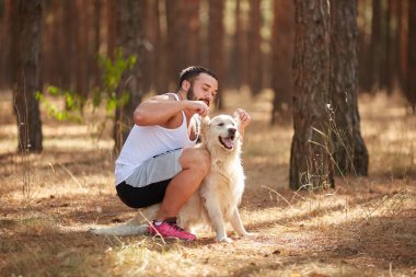 Ormanda açık yürüyen labrador köpek ile güçlü esmer adam.
