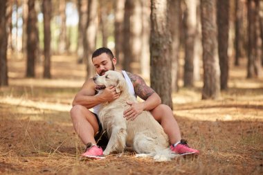 Ormanda açık yürüyen labrador köpek ile güçlü esmer adam.