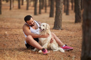 Ormanda açık yürüyen labrador köpek ile güçlü esmer adam.