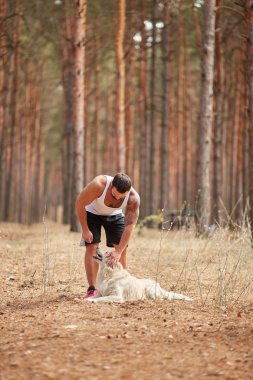 Bir adam bir köpek için a yürümek ormanda okşayarak