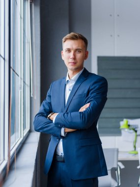 Kendine güvenen, yakışıklı işadamı bulanık bir zemin üzerine mavi elbiseli. Küçük işletme kavramı.