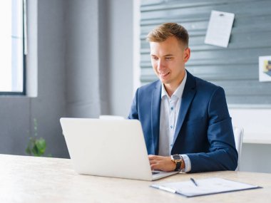 Yakışıklı iş adamı bir dizüstü bilgisayarda office arka plan üzerinde çalışıyor. Dijital teknoloji kavramı. Kopya alanı.